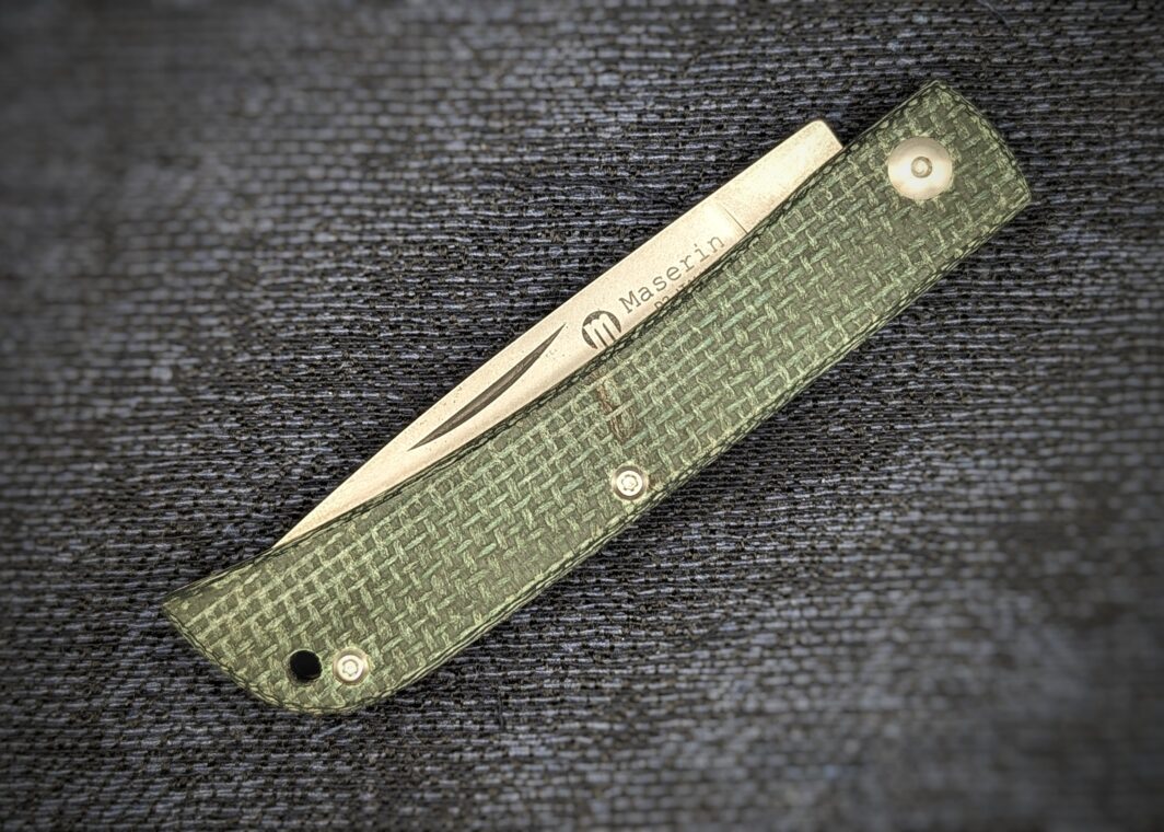 Couteau pliant Scout de Maserin position fermée. Le manche est en micarta tressé vert. Vue du côté gauche avec le poinçon sur la lame qui dépasse du manche. Couteau industriel de marque italienne Coutellerie Châteauneuf-du-Pape, Coutellerie du Pape, Vaucluse