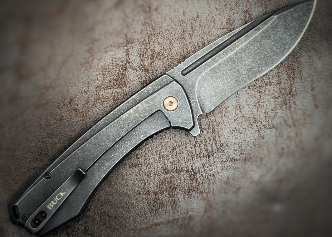 Couteau Ruckus Black de Buck. Ouvert sur côté droit. Le manche est noir. On voit le clip d'attache ceinture avec dessus l'inscription buck. Couteau industriel de marque américaine Coutellerie Châteauneuf-du-Pape, Coutellerie du Pape, Vaucluse