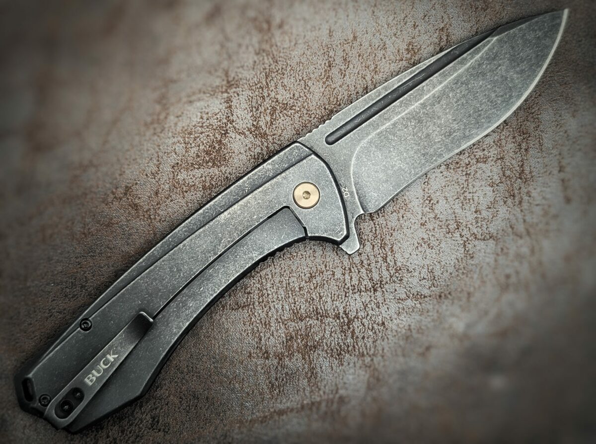 Couteau Ruckus Black de Buck. Ouvert sur côté droit. Le manche est noir. On voit le clip d'attache ceinture avec dessus l'inscription buck. Couteau industriel de marque américaine Coutellerie Châteauneuf-du-Pape, Coutellerie du Pape, Vaucluse