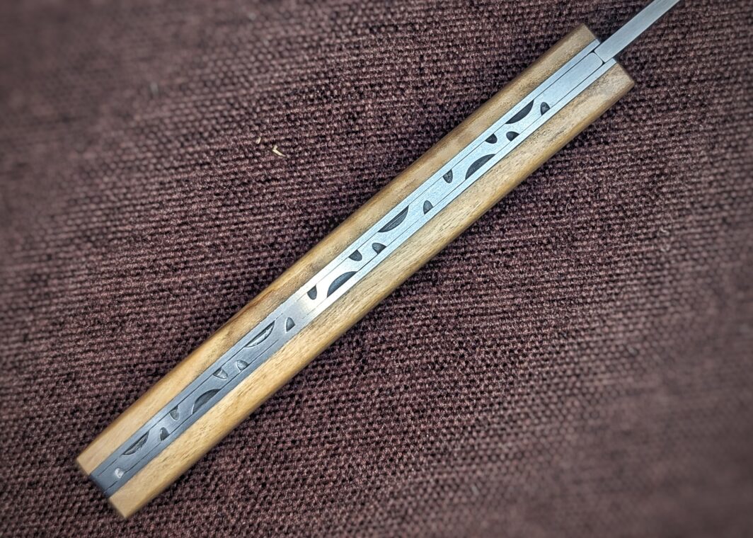 Couteau le Thiers de Le Fidèle ouvert. Manche en olivier. vue sur la guilloche du dos.Couteau industriel de marque française. Couteau célèbre Coutellerie Châteauneuf-du-Pape, Coutellerie du Pape, Vaucluse