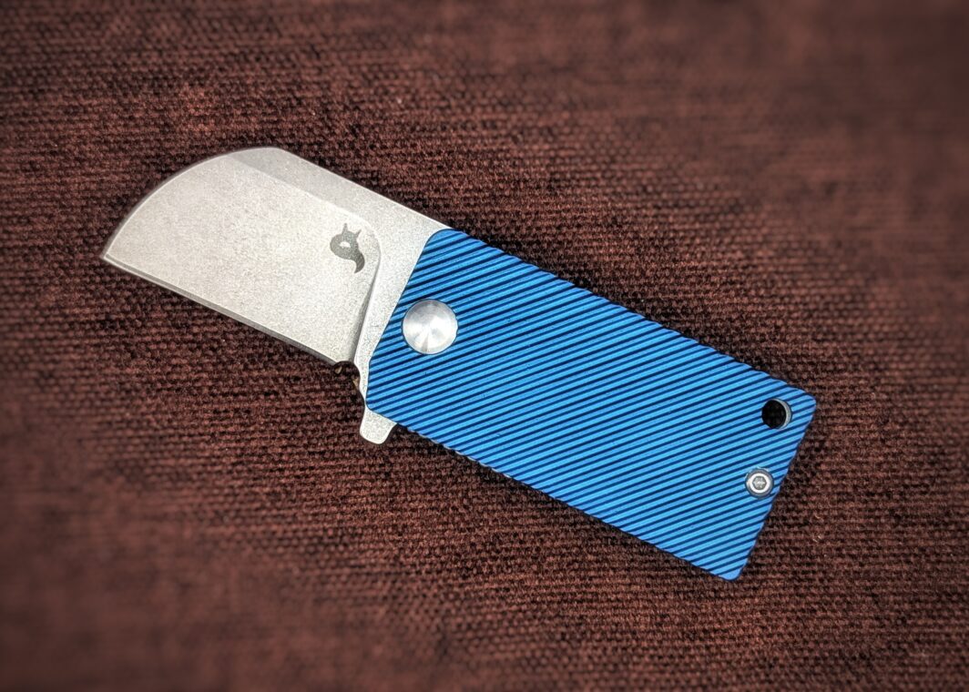 Couteau pliant B.Key de BlackFox. Vue du côté gauche. On voit le poinçon sur la lame. Le manche est en aluminium bleu. Couteau industriel de marque italienne Coutellerie Châteauneuf-du-Pape, Coutellerie du Pape, Vaucluse