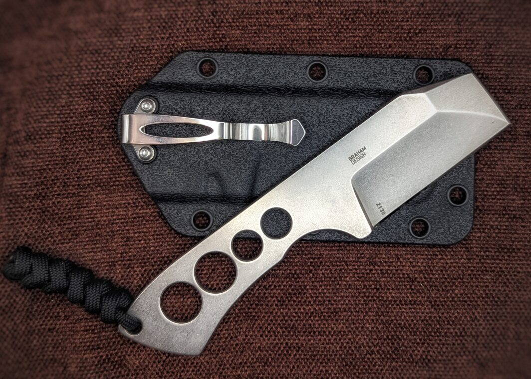 Couteau Razel Chizel de CRKT. Un intégral en acier avec des trous dans le manche. Vue du côté droit. L'étui avec clip pour la ceinture est en fond Couteau industriel de marque américaine Coutellerie Châteauneuf-du-Pape, Coutellerie du Pape, Vaucluse