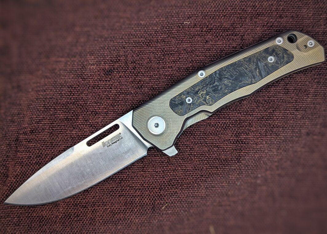 Couteau pliant de Lionsteel. Position ouvert. Côté gauche. La marque est écrite sur la lame. Le manche est jaune et noir. Couteau industriel de marque italienne Coutellerie Châteauneuf-du-Pape, Coutellerie du Pape, Vaucluse