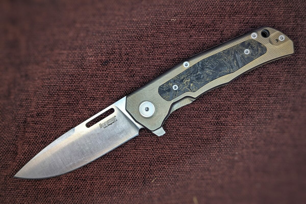 Couteau pliant de Lionsteel. Position ouvert. Côté gauche. La marque est écrite sur la lame. Le manche est jaune et noir. Couteau industriel de marque italienne Coutellerie Châteauneuf-du-Pape, Coutellerie du Pape, Vaucluse