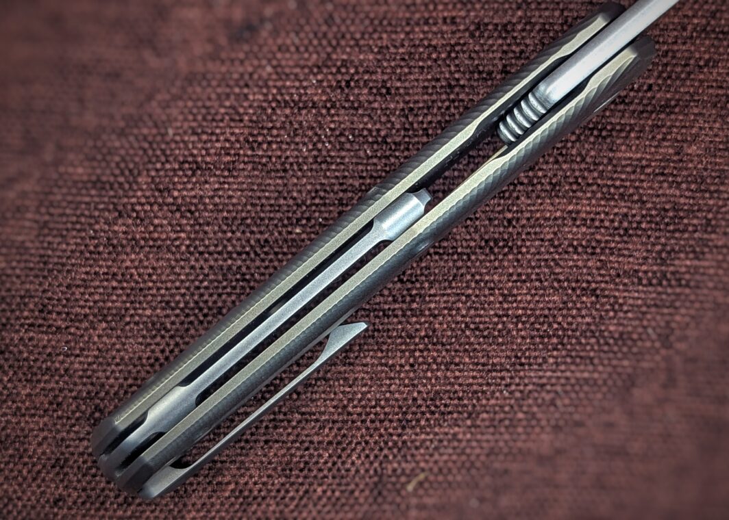 Couteau pliant de Lionsteel. Position ouvert. Vue du dessus. Le manche est jaune et noir. On aperçoit un clip du côté droit pour attacher à la ceinture ou à la poche Couteau industriel de marque italienne Coutellerie Châteauneuf-du-Pape, Coutellerie du Pape, Vaucluse