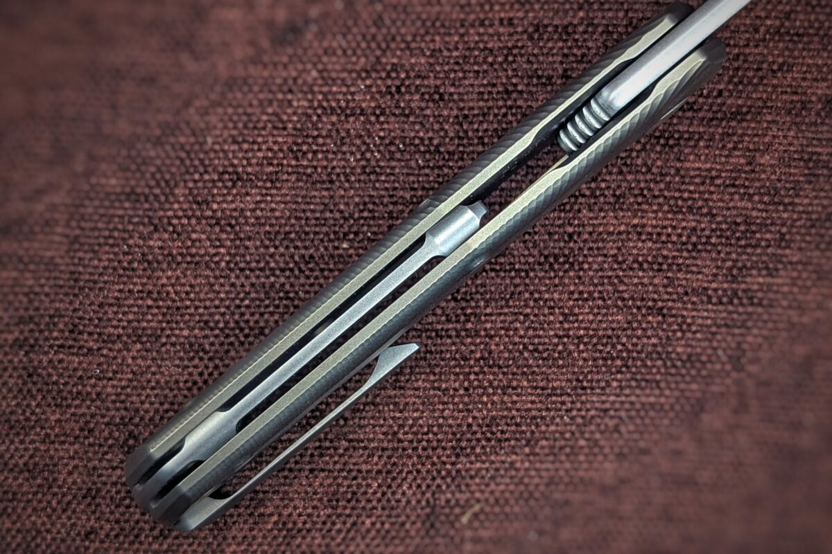 Couteau pliant de Lionsteel. Position ouvert. Vue du dessus. Le manche est jaune et noir. On aperçoit un clip du côté droit pour attacher à la ceinture ou à la poche Couteau industriel de marque italienne Coutellerie Châteauneuf-du-Pape, Coutellerie du Pape, Vaucluse
