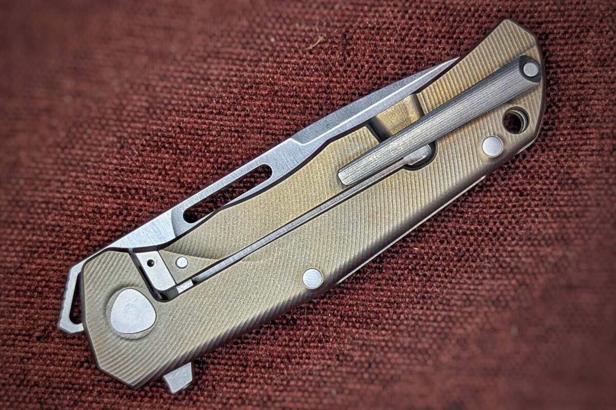 Couteau pliant de Lionsteel. Position fermée. Côté droit. Le manche est jaune. On aperçoit un clip pour attacher à la ceinture ou à la poche Couteau industriel de marque italienne Coutellerie Châteauneuf-du-Pape, Coutellerie du Pape, Vaucluse