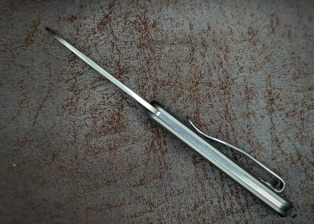 Couteau pliant Vulpis. Position ouverte, vue du dos du couteau. On aperçoit le clip du côté droit pour attacher à la ceinture ou à la poche. Couteau industriel de marque italienne Coutellerie Châteauneuf-du-Pape, Coutellerie du Pape, Vaucluse