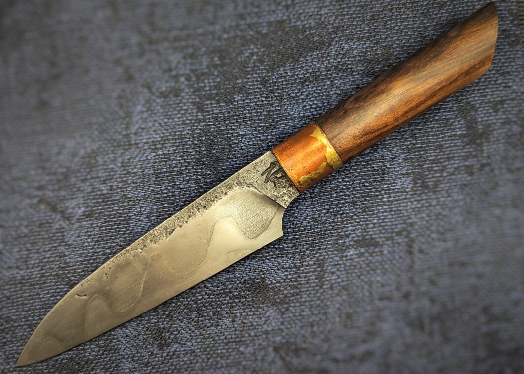 Couteau de cuisine par Noki. Côté gauche. Lame avec trempe sélective à l'argile. Manche en noyer. Bague en cuivre et laiton. Couteau artisanal, coutellerie français à Châteauneuf-du-Pape, Vaucluse Coutellerie du Pape