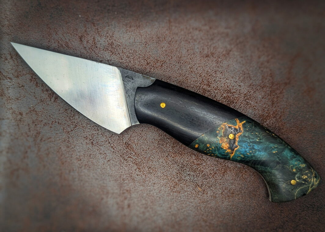 Couteau fixe de l'artisan Lou Marius. Le manche est en ébène et en loupe d'érable stabilisée et teintée verte. Vue du côté gauche. Couteau artisanal, coutellerie français à Châteauneuf-du-Pape, Vaucluse Coutellerie du Pape