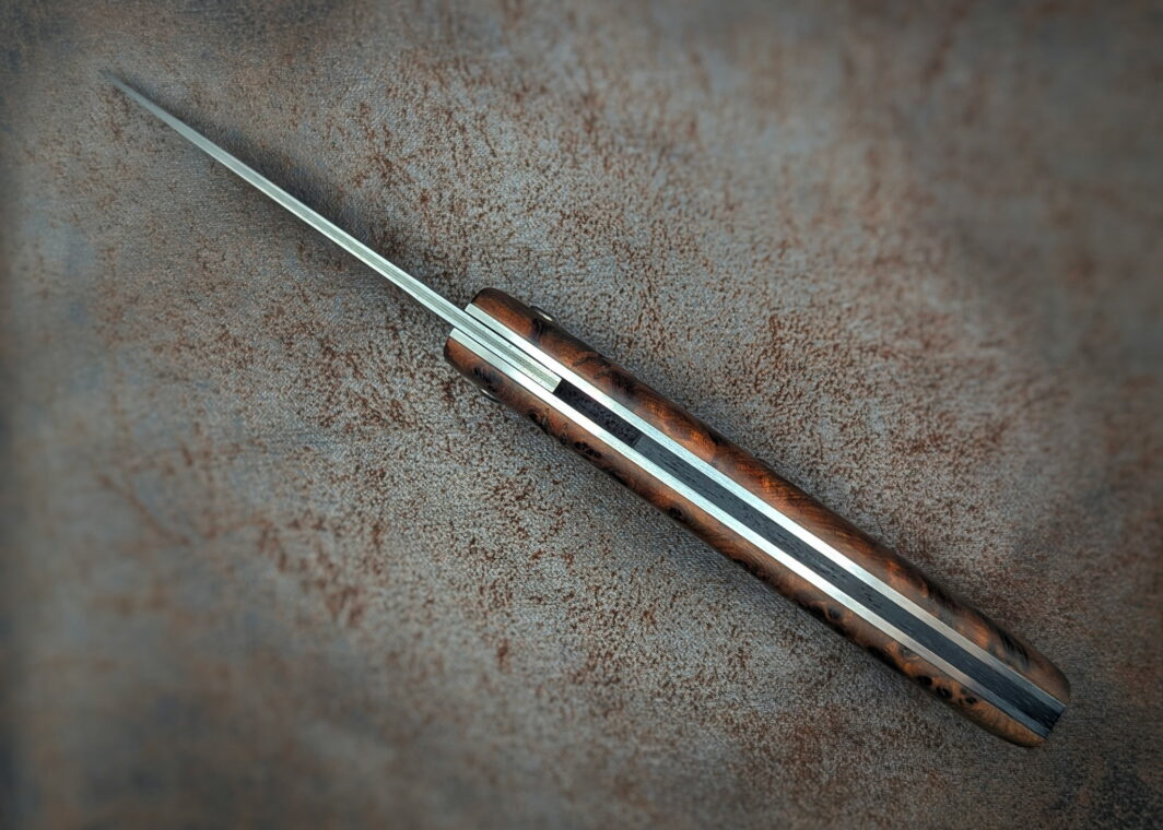 Couteau Piémontais Thuya par l'artisan Dahéna Urli. Vue du dessus, position ouverte. On aperçoit la fausse pièce en ébène. Couteau artisanal, coutellerie français à Châteauneuf-du-Pape, Vaucluse Coutellerie du Pape