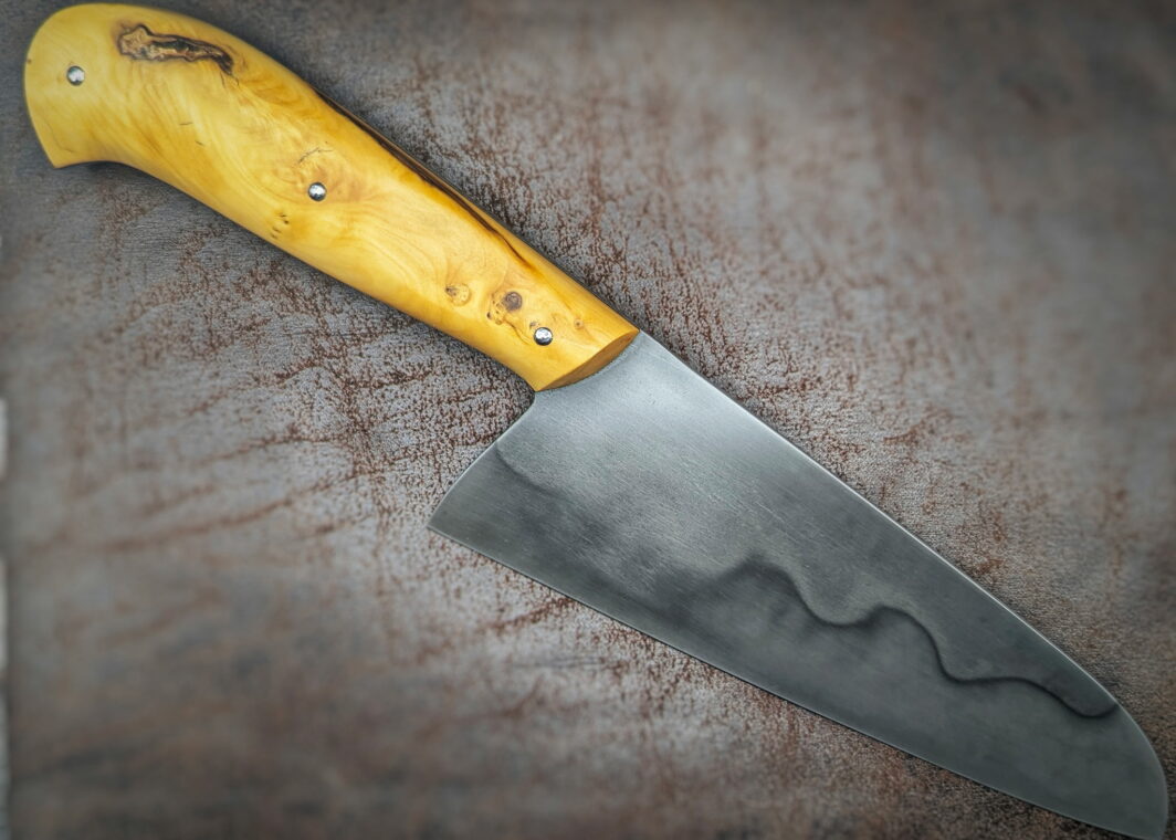 Couteau fixe de cuisine par l'artisan Alban Campagnola. Vue du côté droit. La lame est en C130 avec une révélation d'une trempe sélective au perchlorure de fer. Le manche est en Buis. Couteau artisanal, coutellerie français à Châteauneuf-du-Pape, Vaucluse Coutellerie du Pape