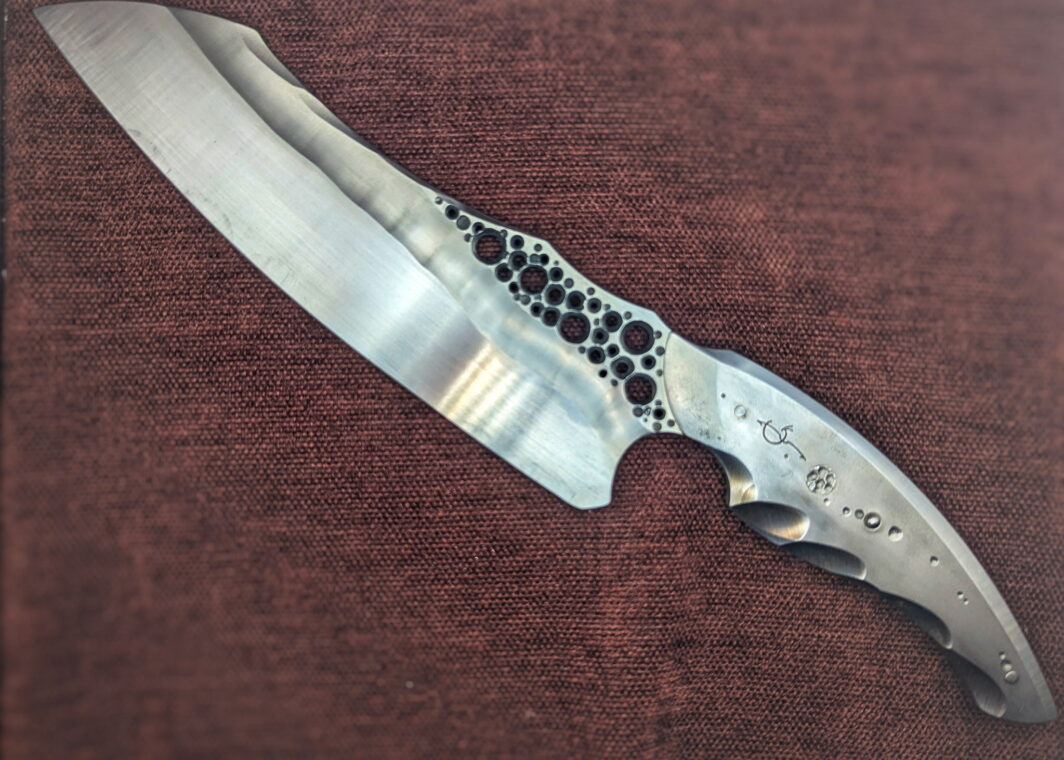 Couteau fixe de cuisine par l'artisan Dracoforge. Vue du côté gauche. Le couteau est totalement fait d'acier inox Z40. La lame est en finition tirée en long. Couteau artisanal, coutellerie français à Châteauneuf-du-Pape, Vaucluse Coutellerie du Pape
