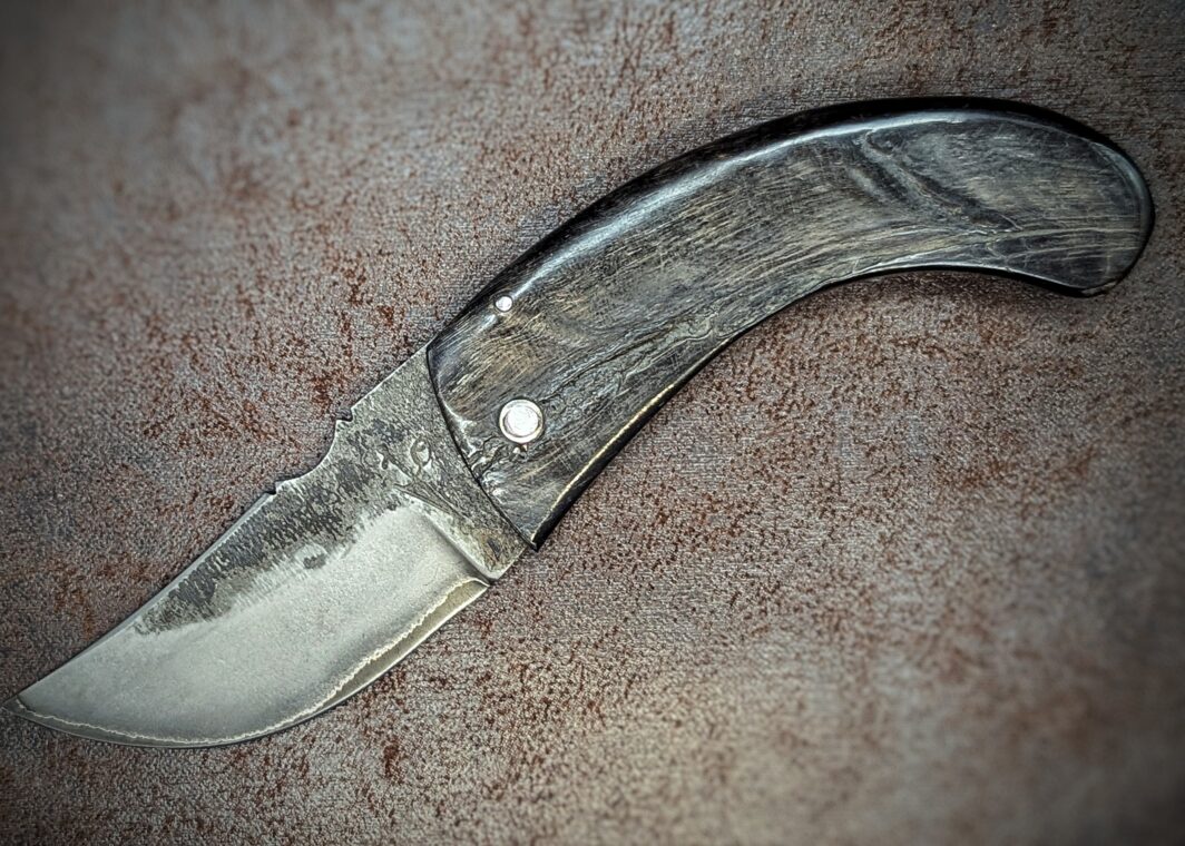 couteau pliant deux clous avec manche en corne de bélier et lame en San Maï position ouverte, coté gauche