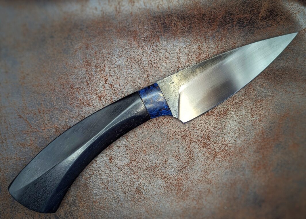 Couteau fixe, soie par Lou Marius. Manche en ébène, bague en bouleau stabilisé bleu. Côté droit