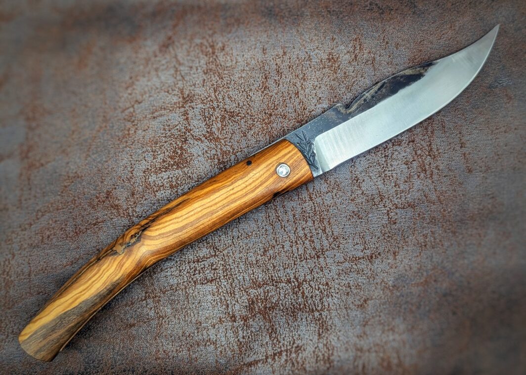 Couteau pliant de poche par José Viale. Manche en Olivier. Lame en carbone XC75. Position ouverte, côté droit