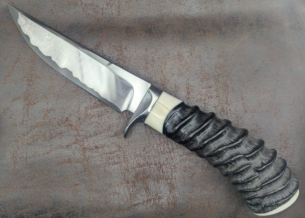 couteau par José Viale. Manche en corne de springbok et ivoire de phacochère. Lame en sandwich carbone. Vue côté gauche