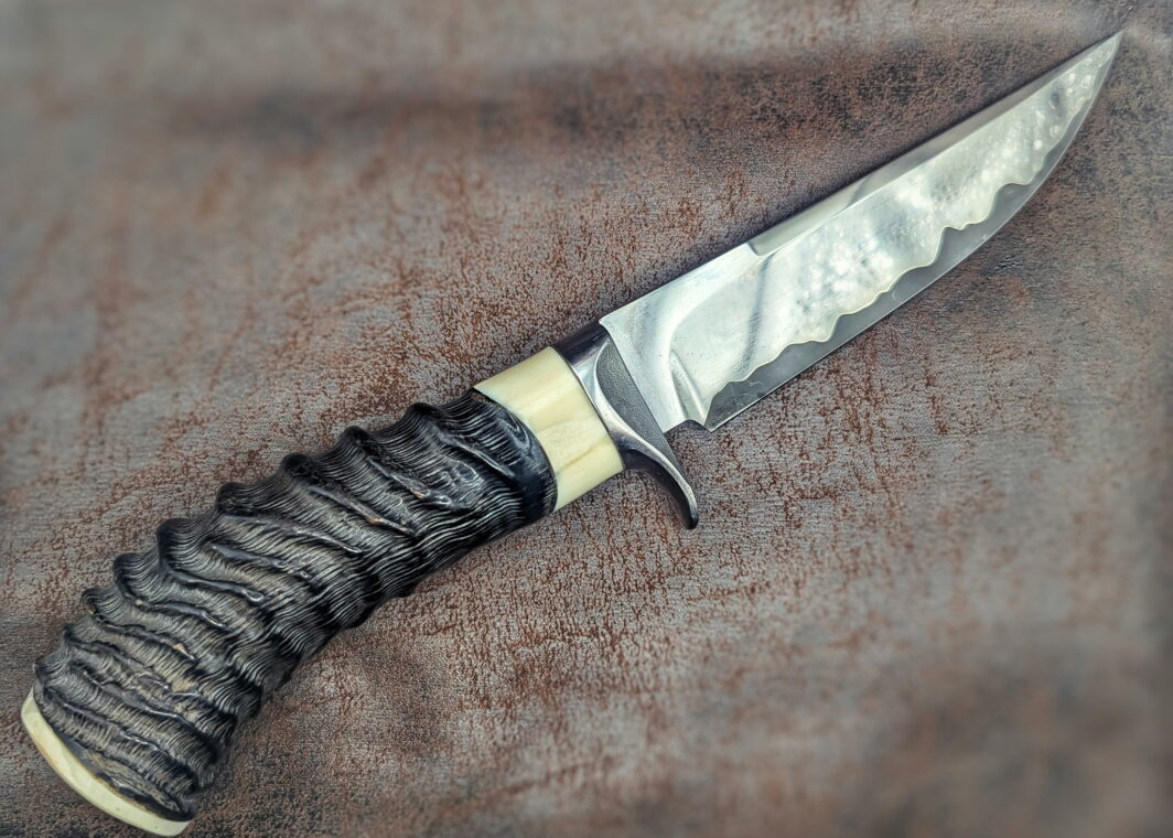 couteau par José Viale. Manche en corne de springbok et ivoire de phacochère. Lame en sandwich carbone. Vue côté droit