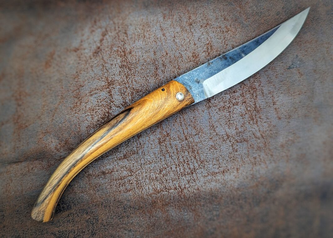 Couteau pliant artisanal par José Viale. Lame en XC75, manche en olivier. Position ouvert, vue du côté droit