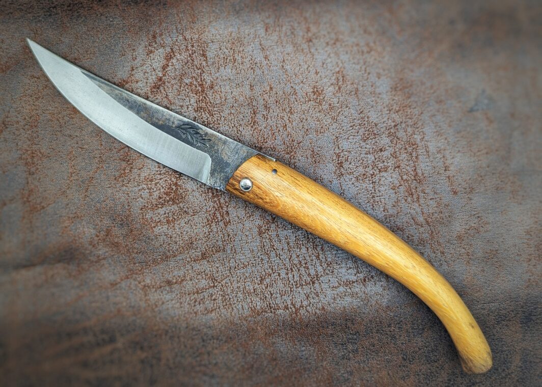 Couteau pliant artisanal par José Viale. Lame en XC75, manche en olivier. Position ouvert, vue du côté gauche