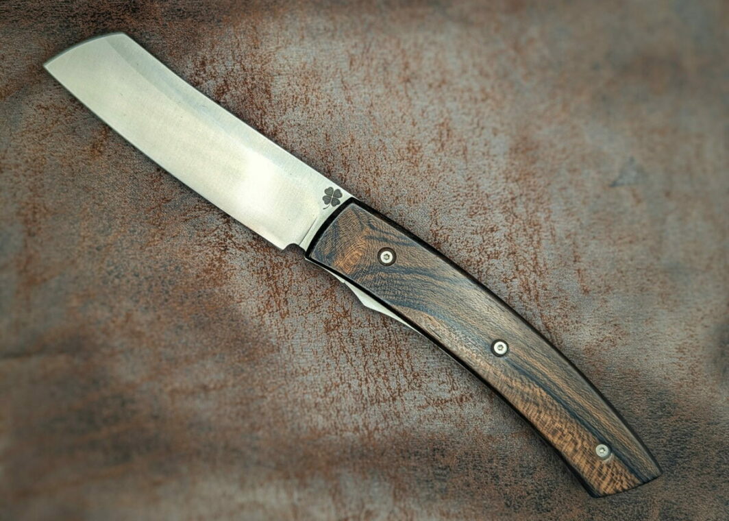 Couteau artisanal pliant par Couteau Trèfle. Lame en inox 14C28, manche en ziricote. Position ouverte, vue du dessus sur le côté gauche