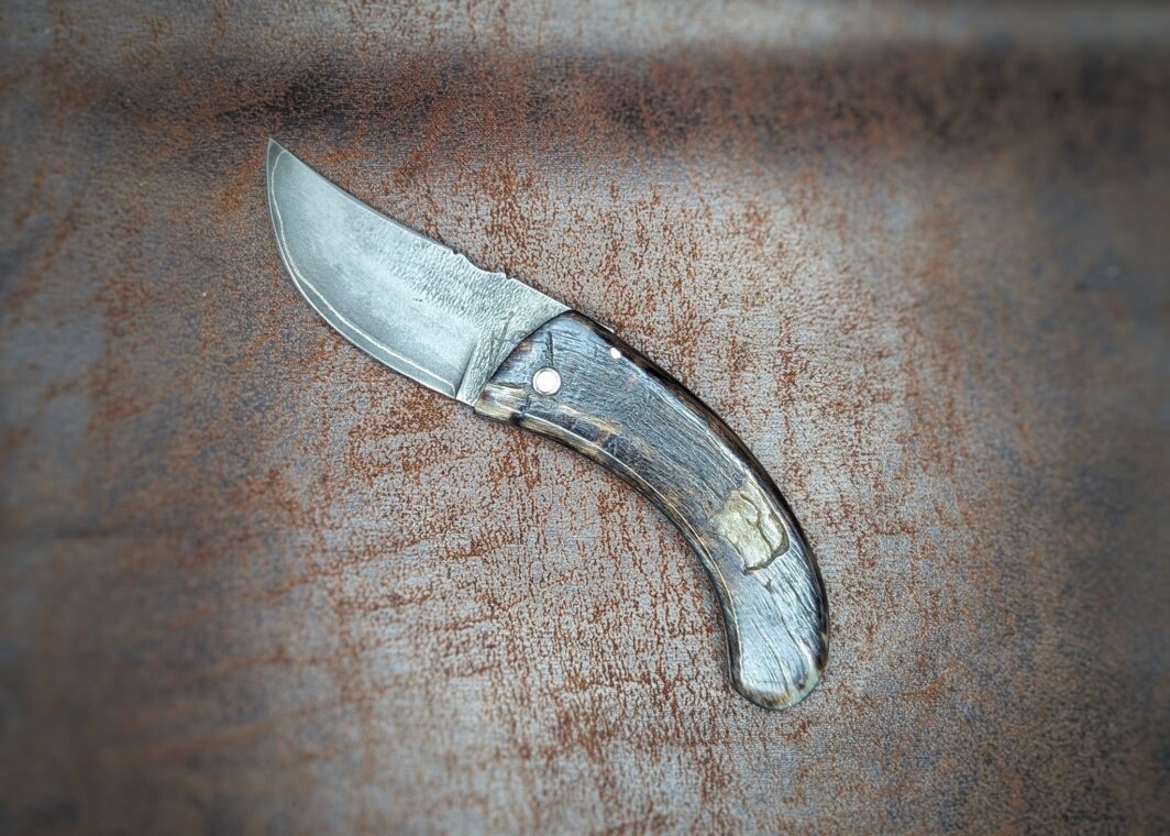 Couteau San Maï par l'artisan José Viale. Lame en San Maï. Manche en corne de bélier. Position ouverte, côté gauche