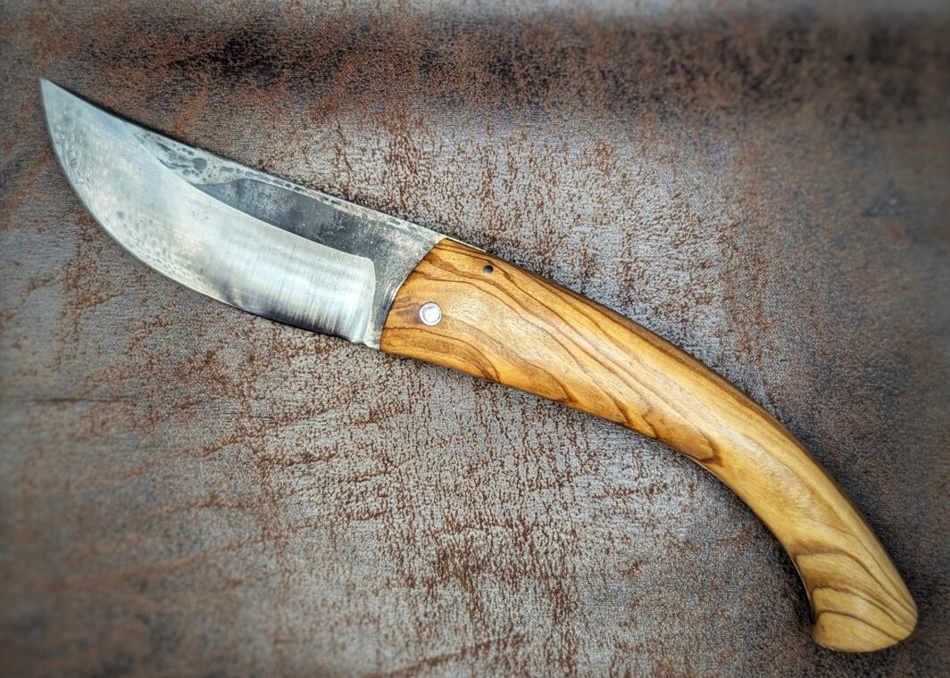 Couteau Berger par l'artisan José Viale. Lame en XC75. Manche en olivier. Position ouvert, côté gauche