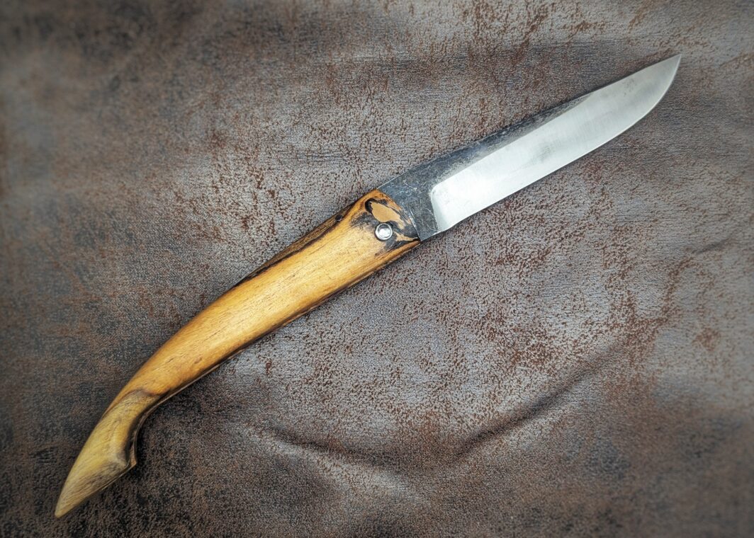 Couteau pliant Capulagui de l'artisan José Viale. Lame en XC75, acier Carbone. Manche en olivier
