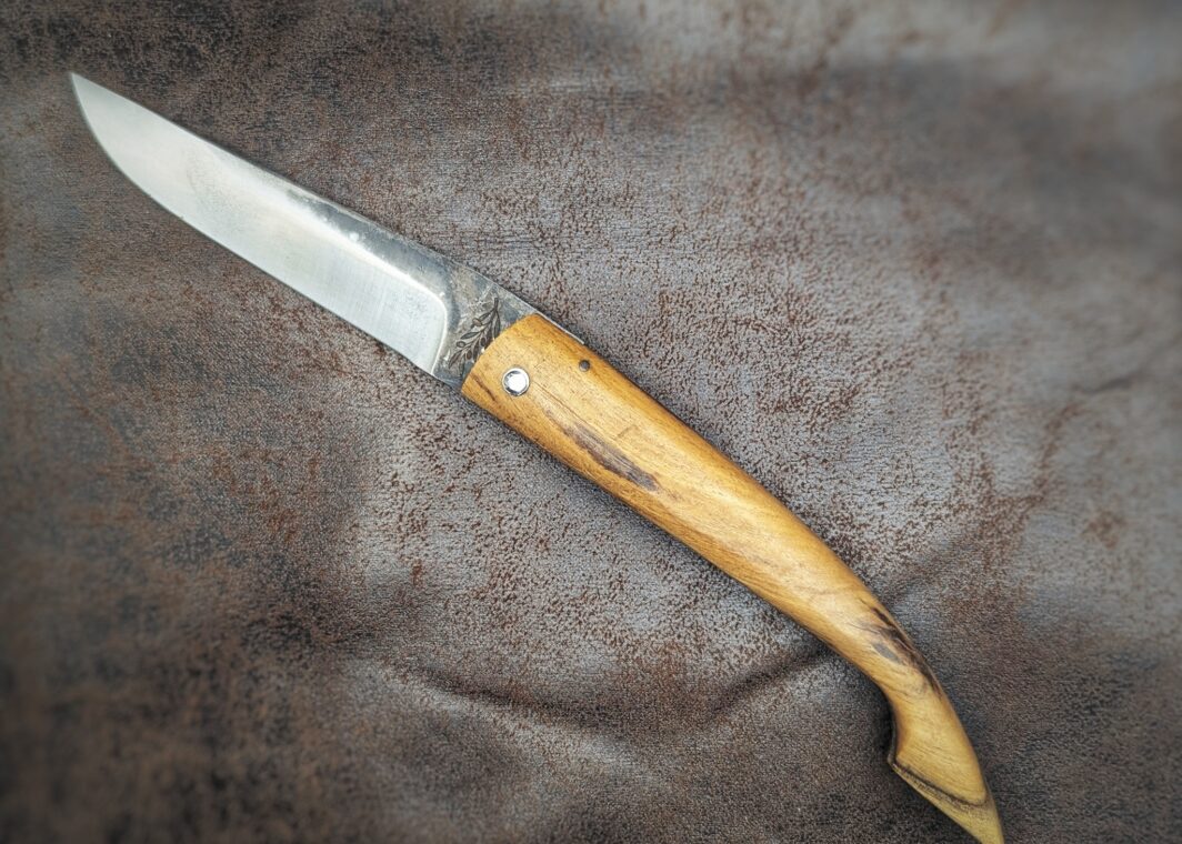 Couteau pliant Capulagui de l'artisan José Viale. Lame en XC75, acier Carbone. Manche en olivier