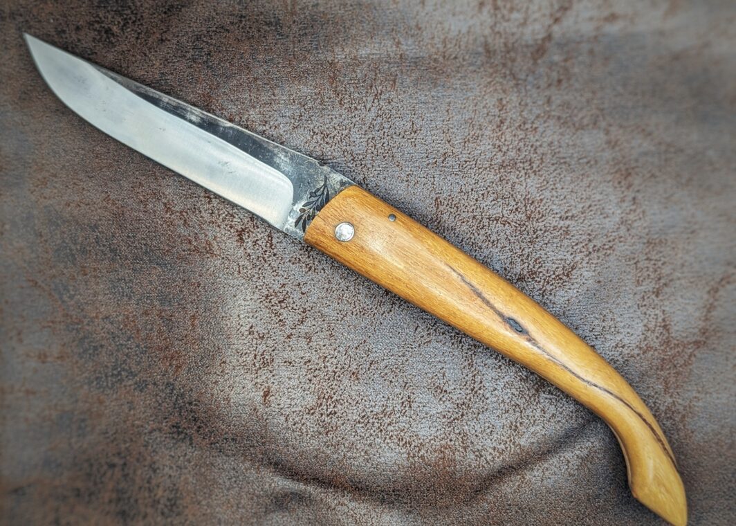 Couteau pliant Capulagui de l'artisan José Viale. Lame en XC75, acier Carbone. Manche en olivier