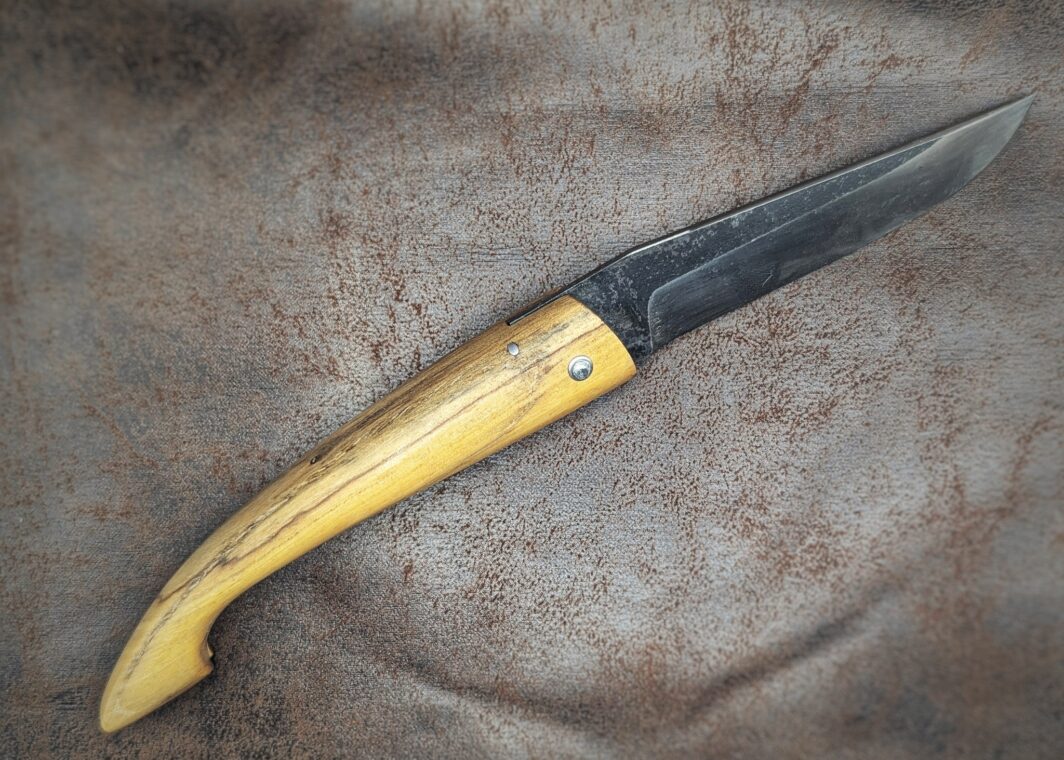 Couteau pliant Capulagui de l'artisan José Viale. Lame en XC75, acier Carbone. Manche en olivier
