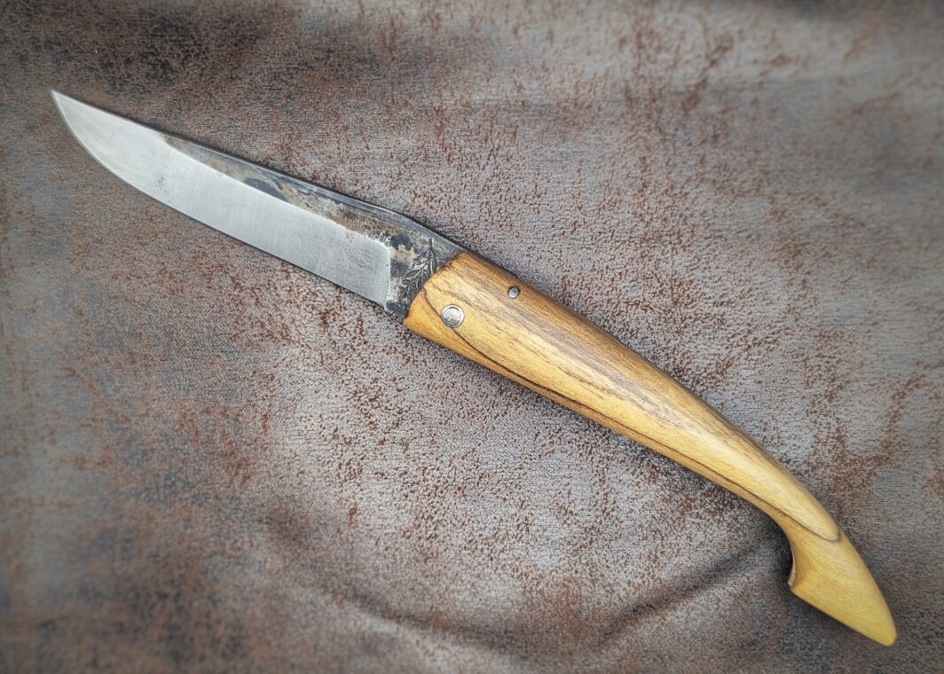 Couteau pliant Capulagui de l'artisan José Viale. Lame en XC75, acier Carbone. Manche en olivier