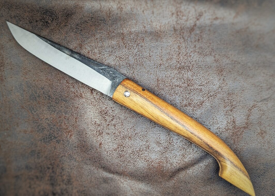 Couteau pliant Capulagui de l'artisan José Viale. Lame en XC75, acier Carbone. Manche en olivier