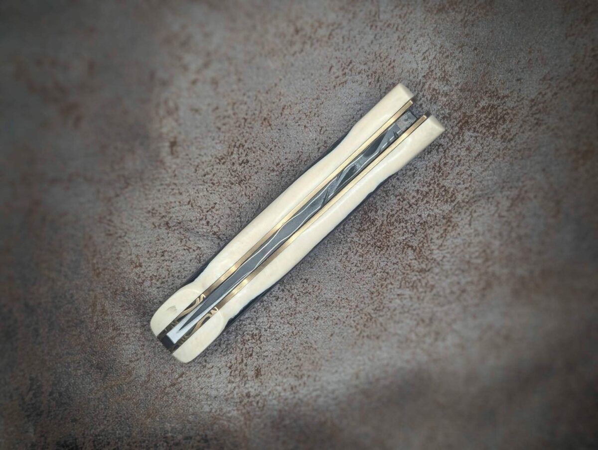 Couteau pliant par l'artisan Dahéna URLI. Lame en acier sandwich carbone, manche en ivoire de mammouth et abalone. Position fermé, vue du dessous