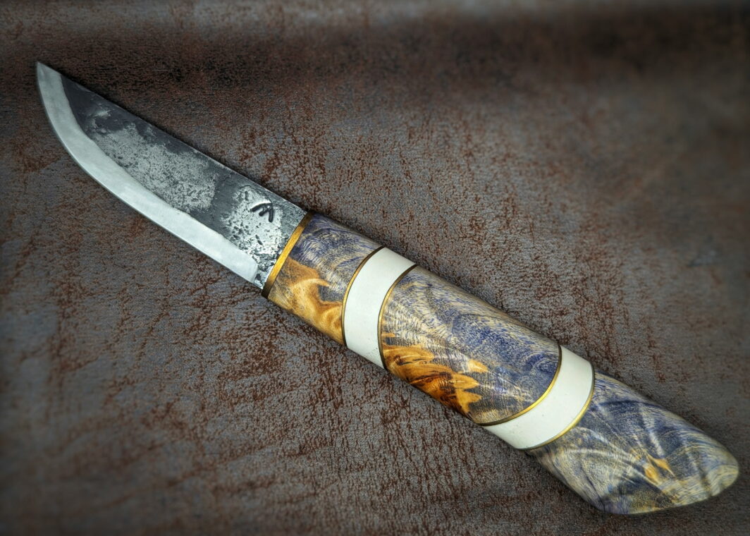 Couteau fixe puukko artisanal forgé par Tête d'Enclume. 'Le Baiser' lame en 80CRV2 et manche en Fourche de peuplier, Laiton et Elforyn. Côté gauche