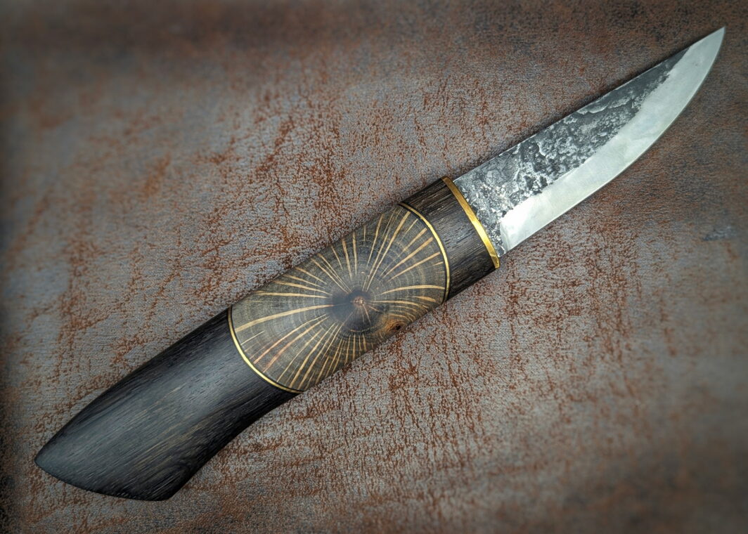 Couteau fixe puukko artisanal forgé par Tête d'Enclume. 'Shai Hulud' lame en 80CRV2 et manche enMorta, Laiton et Chêne en bois debout. Côté droit