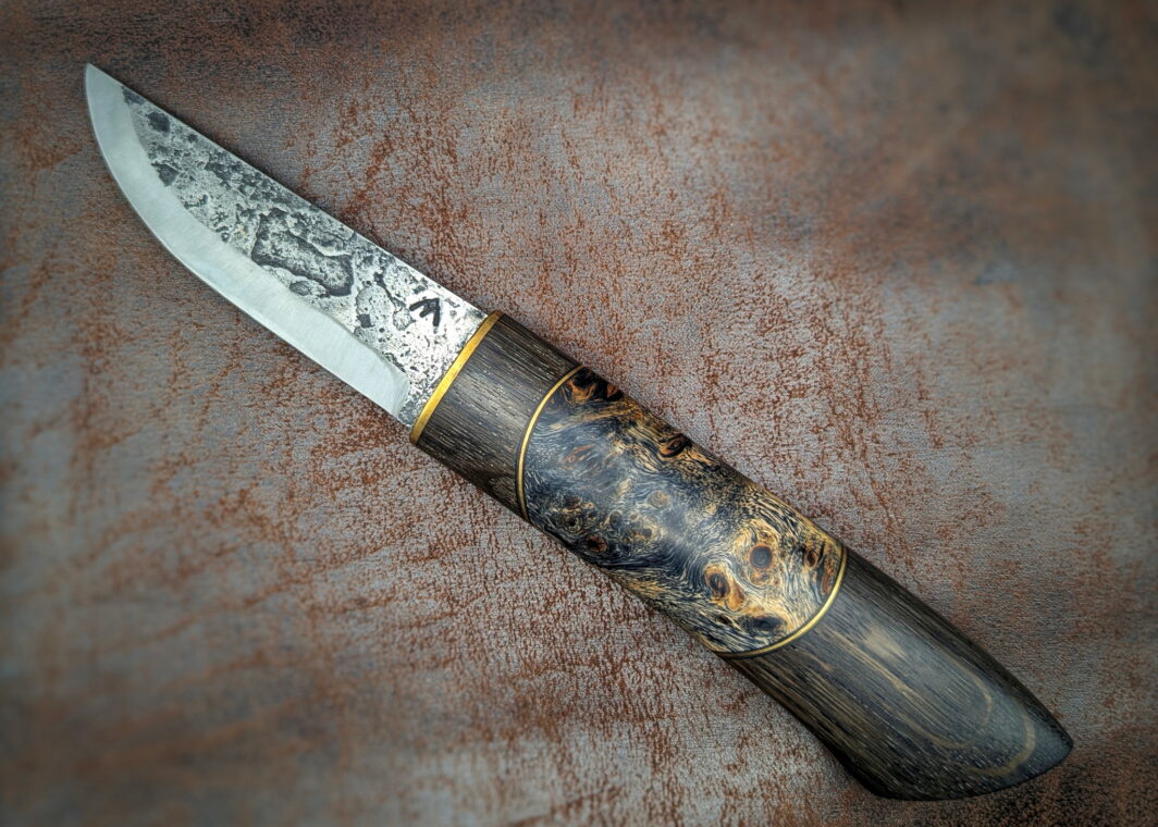 Couteau fixe puukko artisanal forgé par Tête d'Enclume. 'Nuit Etoilée' lame en 80CRV2 et manche en Morta, Laiton et Loupe de Peuplier. Côté Gauche
