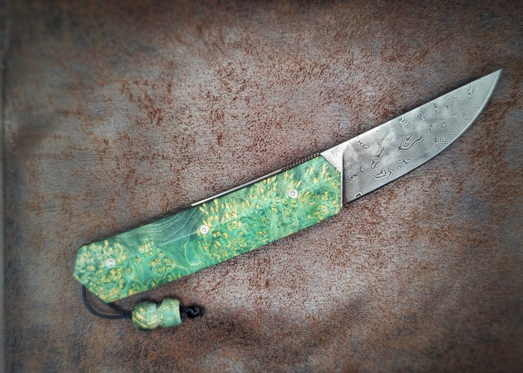 Couteau pliant Liner Lock 'Kiru' de l'artisan Noki. Position ouvert, côté droit. Lame en damas 208 couches. Avec étui en cuir noir. Couteau artisanal français à Châteauneuf-du-Pape, Vaucluse Coutellerie du Pape