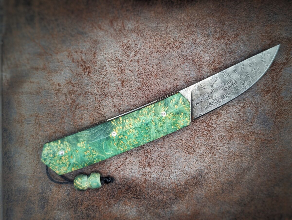 Couteau pliant Liner Lock 'Kiru' de l'artisan Noki. Position ouvert, côté droit. Lame en damas 208 couches. Avec étui en cuir noir. Couteau artisanal français à Châteauneuf-du-Pape, Vaucluse Coutellerie du Pape