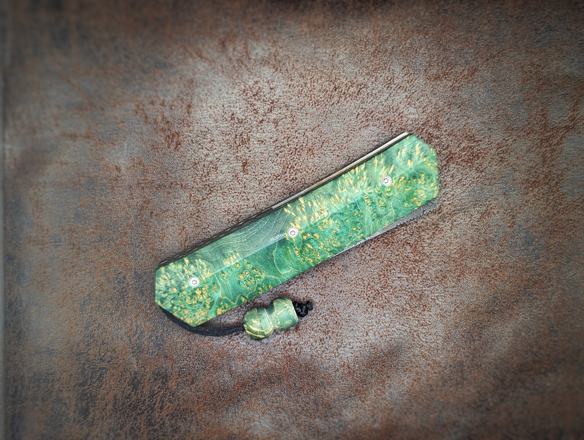 Couteau pliant Liner Lock 'Kiru' de l'artisan Noki. Position fermée, côté droit. Lame en damas 208 couches. Avec étui en cuir noir. Couteau artisanal français à Châteauneuf-du-Pape, Vaucluse Coutellerie du Pape