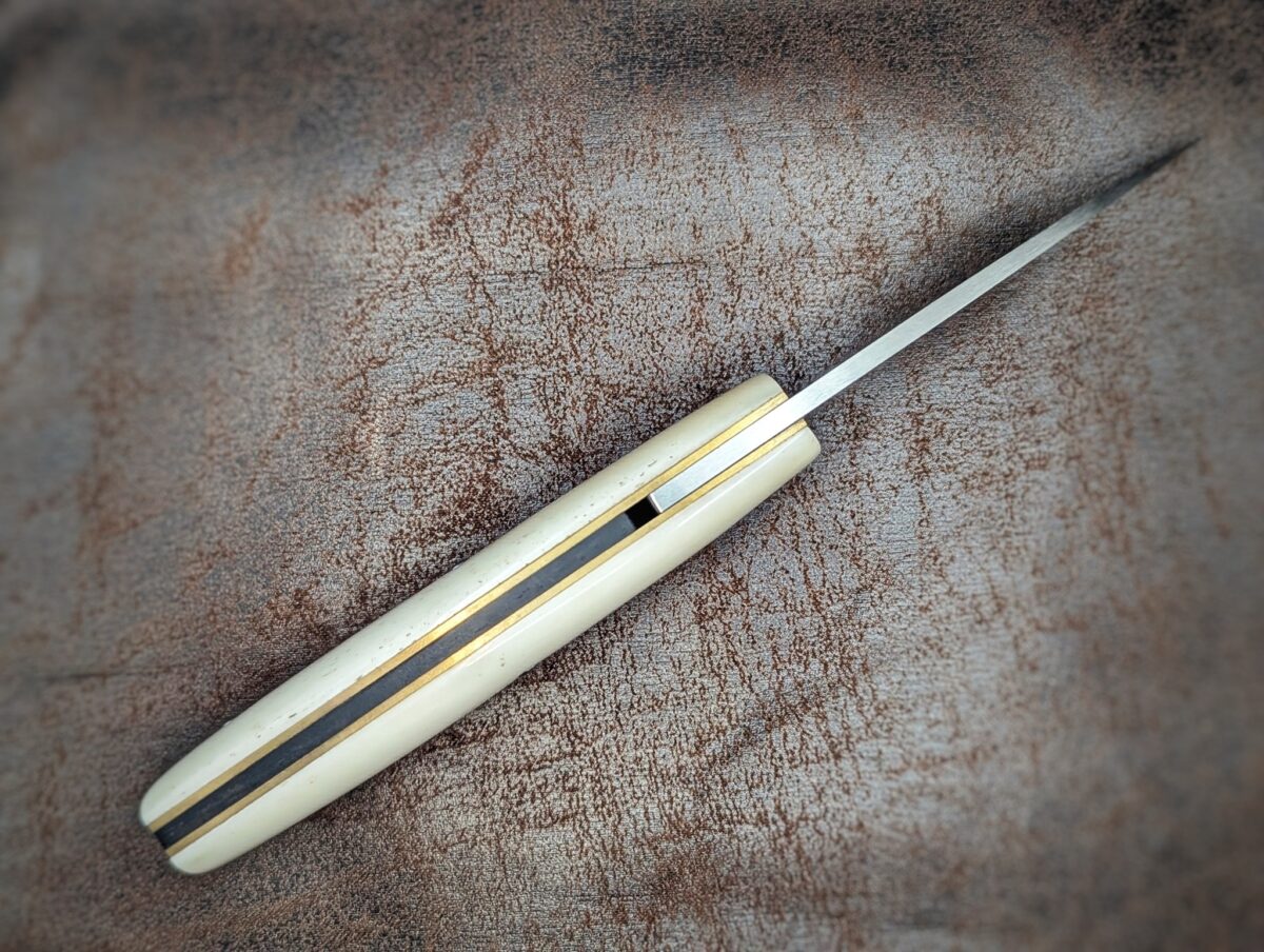 Couteau piémontais artisanal par Dahéna URLI. Lame en inox Z40 et manche en os de chameau. Platines en laiton. Position ouvert, vue du dessus